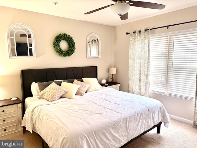 bedroom with multiple windows, ceiling fan, and carpet