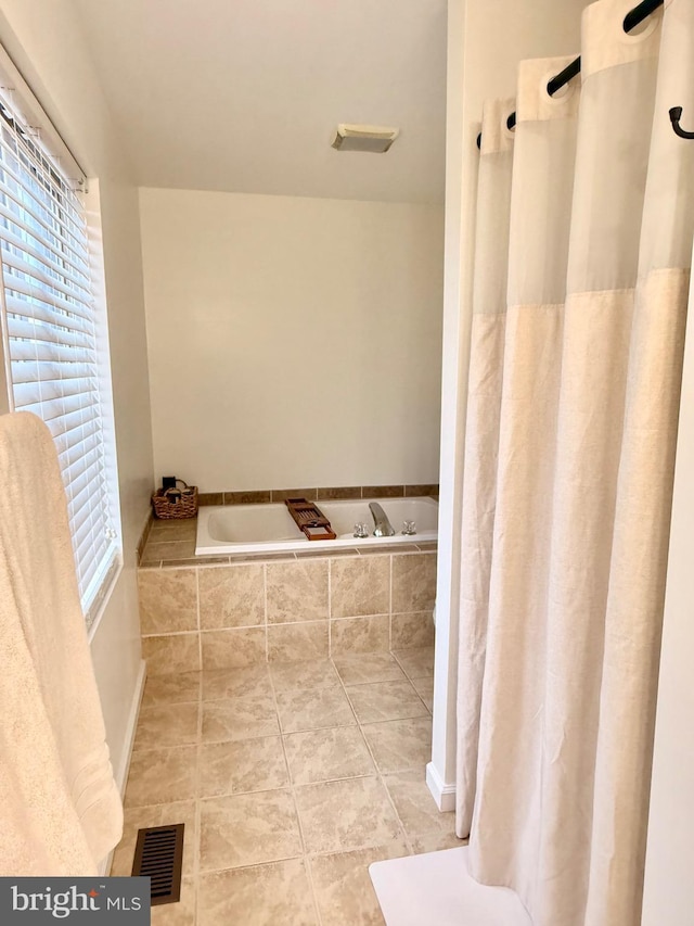 bathroom featuring tiled bath and tile patterned floors