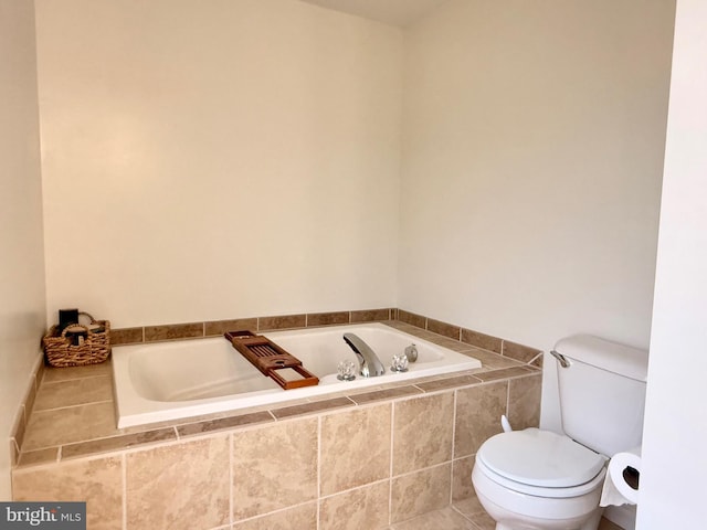 bathroom with tiled tub and toilet