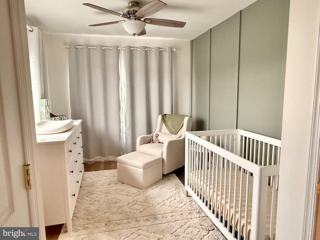 bedroom featuring a crib and ceiling fan