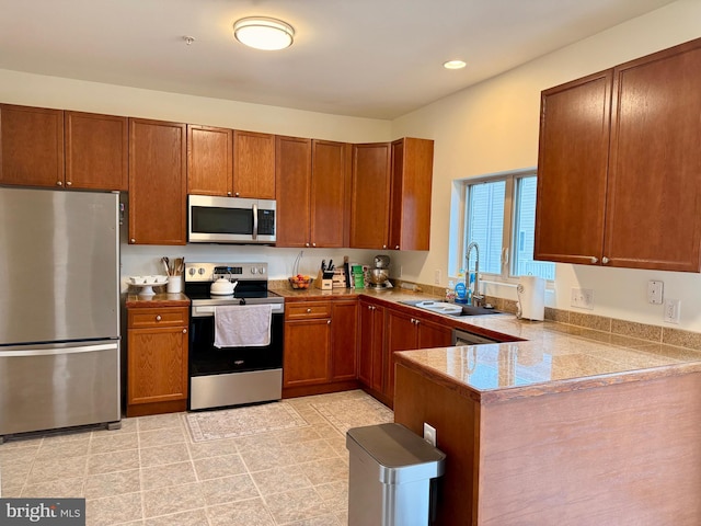 kitchen with appliances with stainless steel finishes, sink, and kitchen peninsula