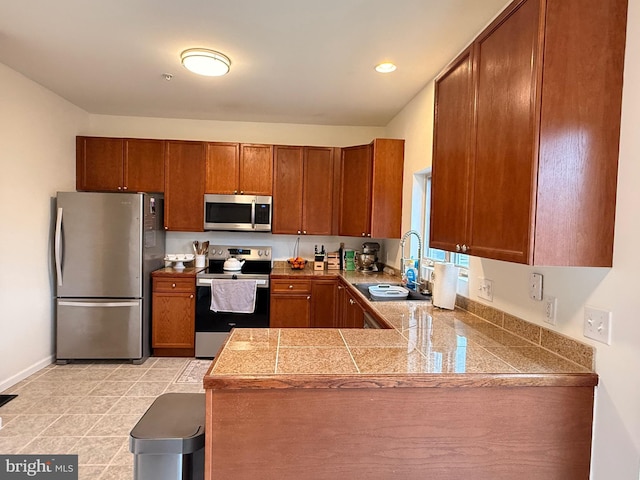 kitchen with sink, light tile patterned floors, stainless steel appliances, and kitchen peninsula