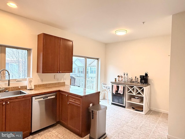 kitchen featuring plenty of natural light, sink, stainless steel dishwasher, and kitchen peninsula