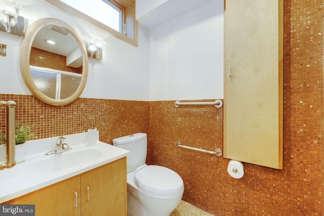 full bath with a wainscoted wall, tile walls, visible vents, toilet, and vanity