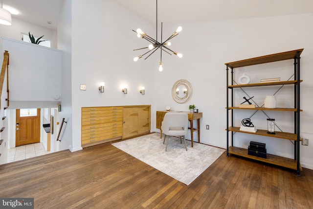 interior space featuring a high ceiling, an inviting chandelier, and hardwood / wood-style flooring