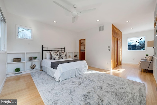 bedroom with light wood-style floors, multiple windows, and visible vents