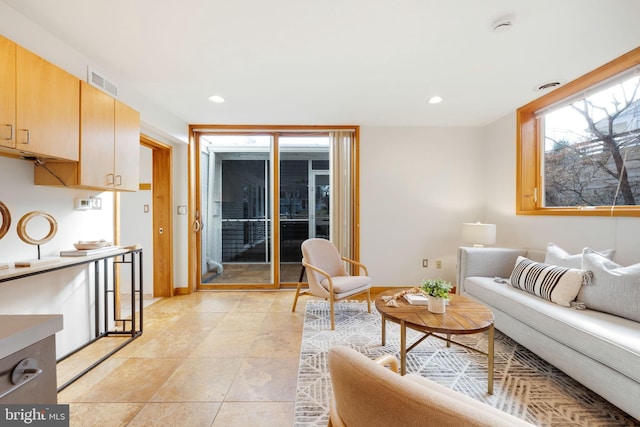 living room with light tile patterned floors, visible vents, and recessed lighting