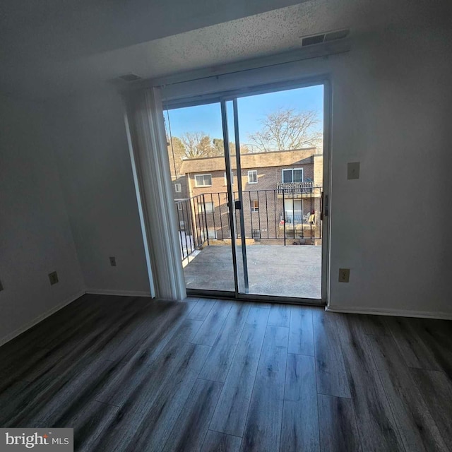 empty room featuring dark wood finished floors and baseboards