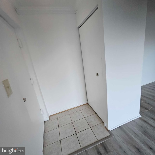 unfurnished bedroom featuring a closet, light wood-type flooring, and baseboards