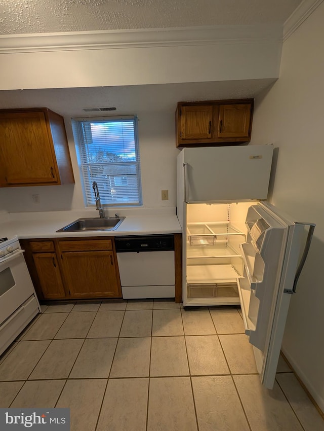 kitchen with crown molding, light tile patterned floors, a sink, range, and dishwasher