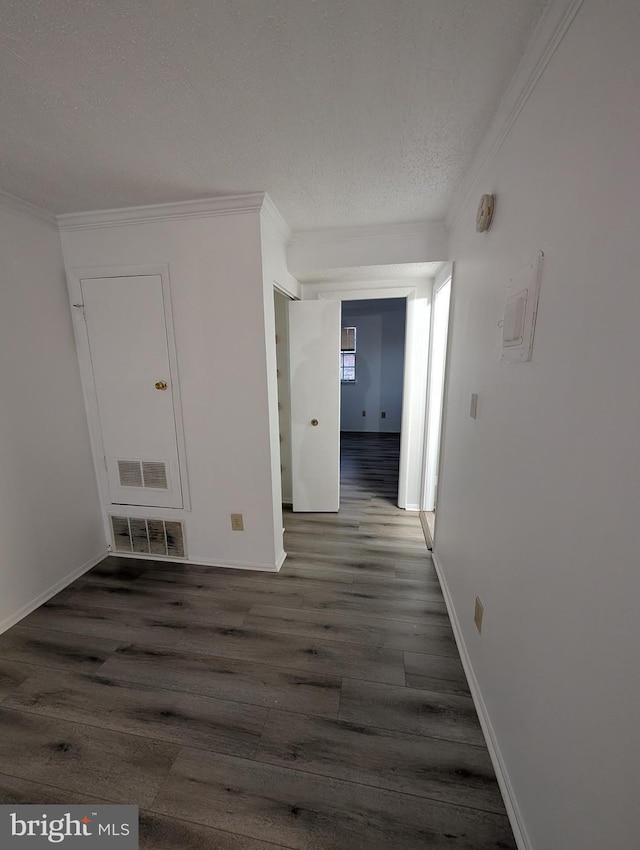 corridor featuring a textured ceiling, visible vents, crown molding, and wood finished floors