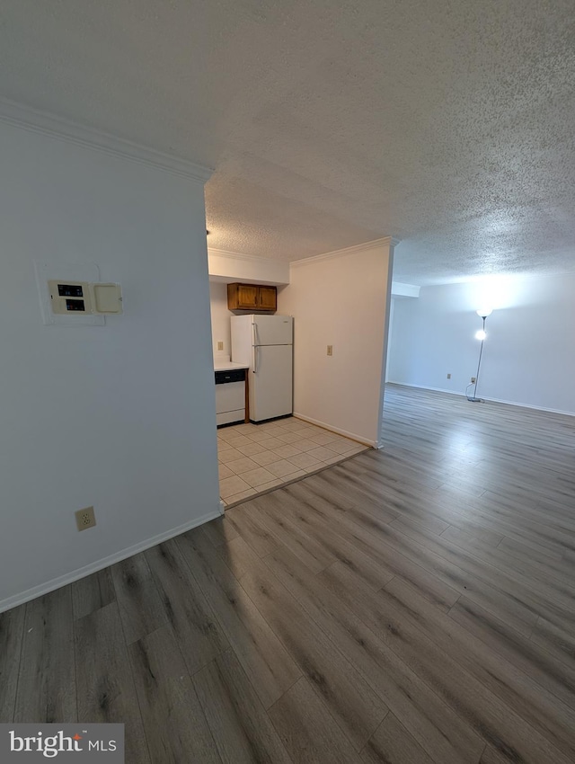 unfurnished room featuring crown molding, a textured ceiling, and light wood finished floors