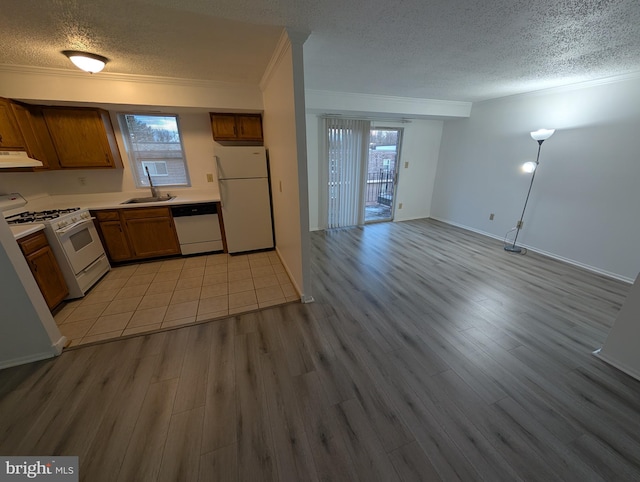 kitchen with light wood-type flooring, white appliances, under cabinet range hood, and a textured ceiling