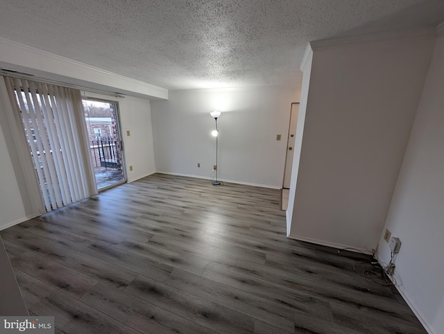 empty room featuring ornamental molding, a textured ceiling, baseboards, and wood finished floors