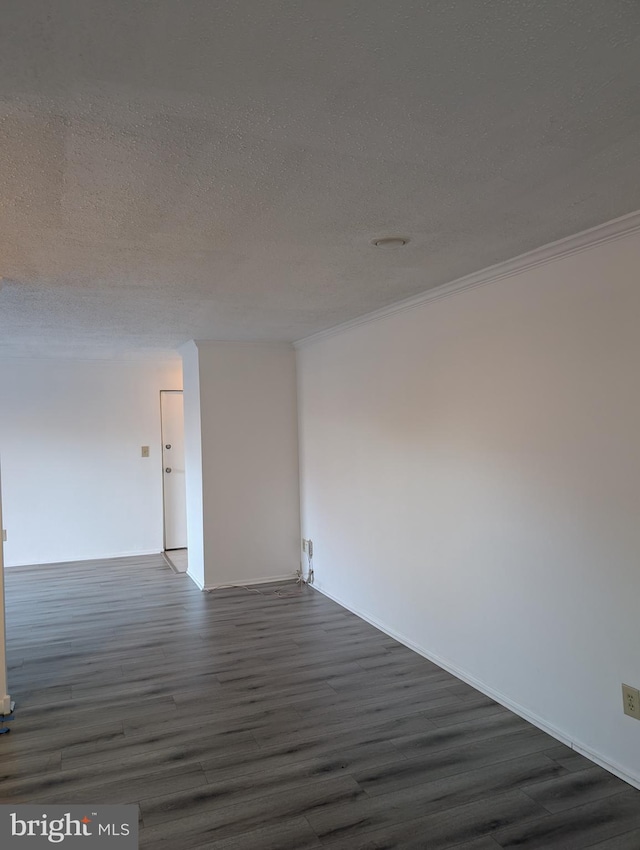 empty room featuring a textured ceiling, dark wood-style flooring, and crown molding