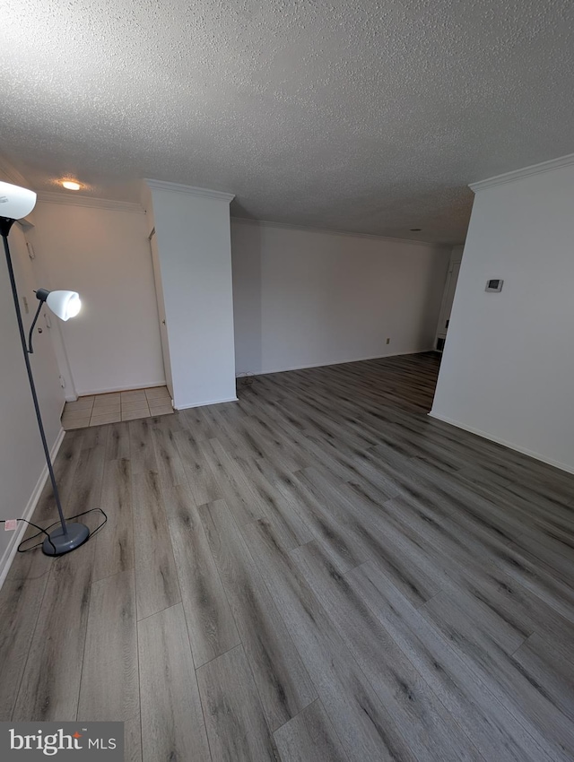 unfurnished living room featuring a textured ceiling and wood finished floors