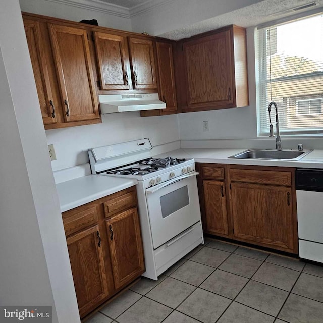 kitchen with under cabinet range hood, white appliances, a sink, light countertops, and brown cabinetry