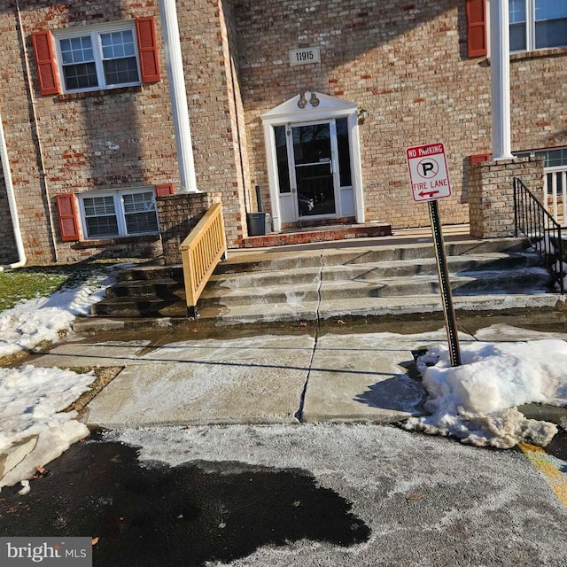 doorway to property with brick siding