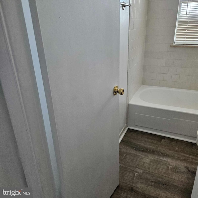 bathroom with bathtub / shower combination and wood finished floors