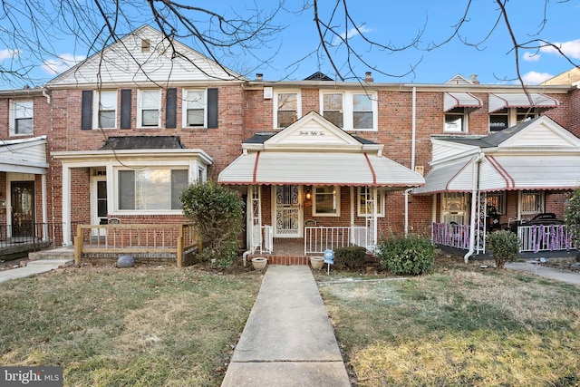 view of property featuring a porch and a front yard