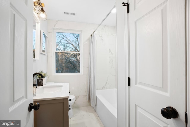 full bathroom with vanity, shower / bath combo with shower curtain, and toilet