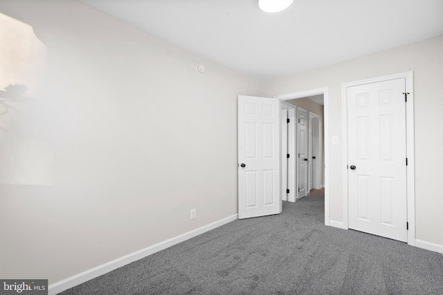 unfurnished bedroom featuring dark carpet