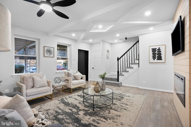 living room featuring coffered ceiling, ceiling fan, beam ceiling, and light hardwood / wood-style flooring