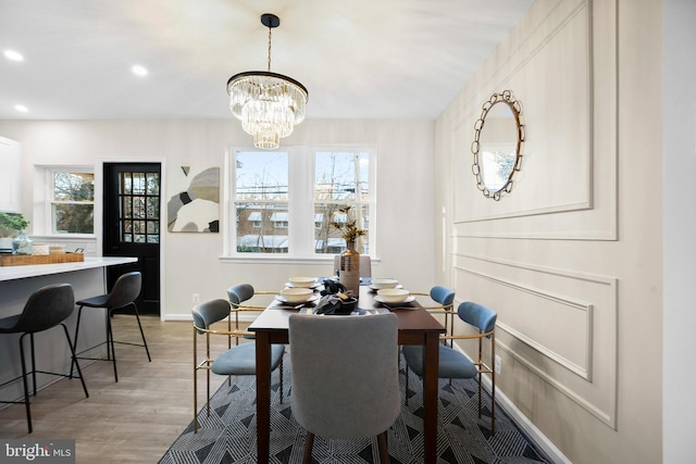 dining space featuring an inviting chandelier, a healthy amount of sunlight, and wood-type flooring