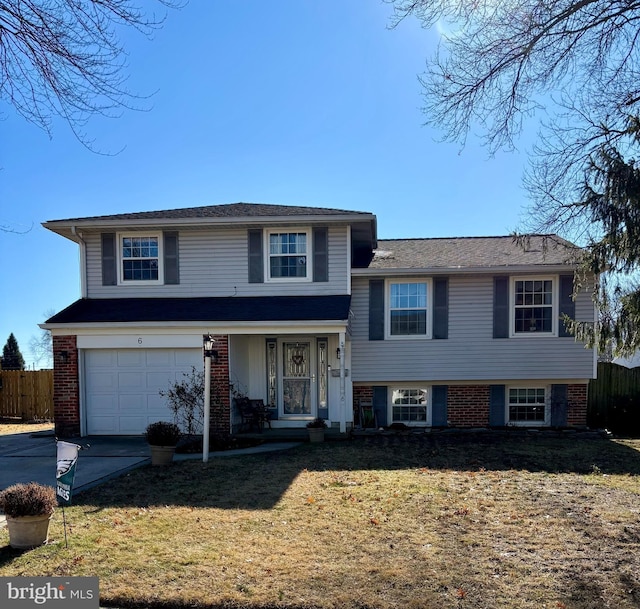 tri-level home featuring a garage and a front lawn