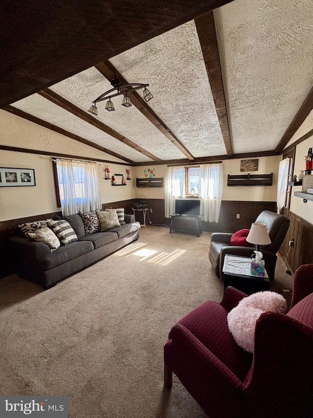 carpeted living room with a wealth of natural light, lofted ceiling with beams, a wall unit AC, and a textured ceiling