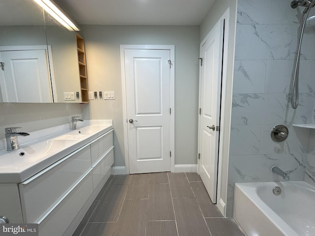 bathroom featuring tiled shower / bath and vanity