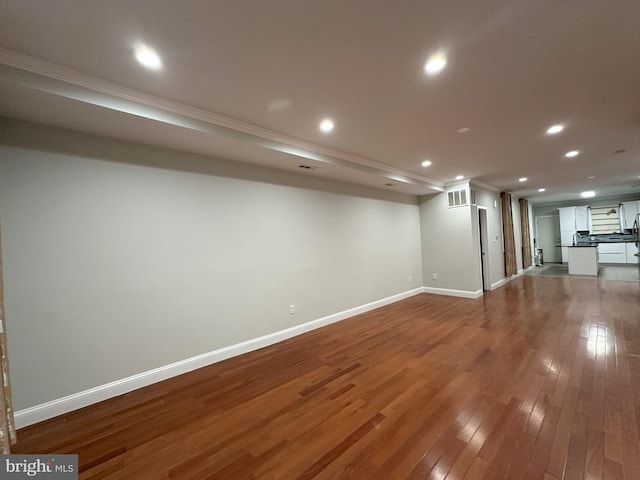 basement featuring hardwood / wood-style flooring and ornamental molding