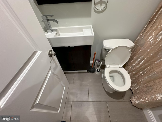 bathroom with tile patterned flooring, vanity, and toilet