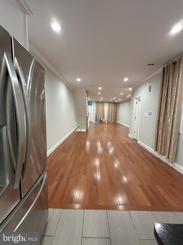 interior space featuring wood-type flooring, crown molding, and stainless steel fridge with ice dispenser