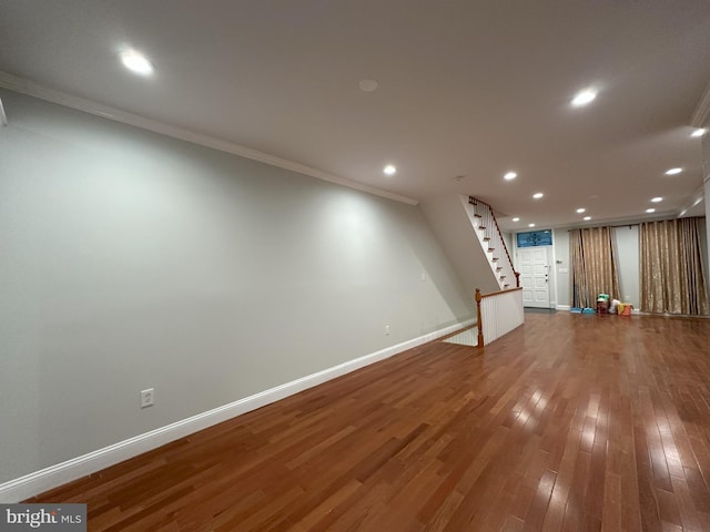 basement featuring hardwood / wood-style floors and crown molding