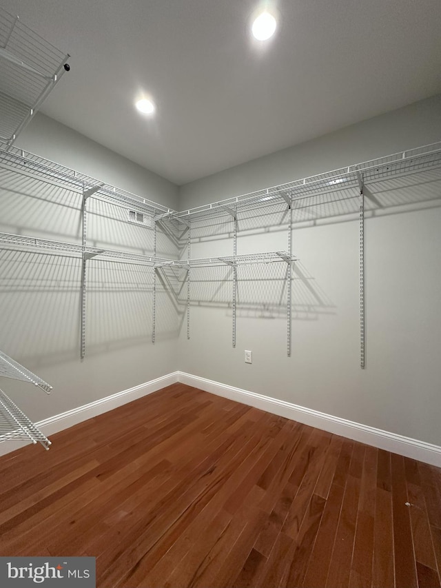 walk in closet with hardwood / wood-style flooring