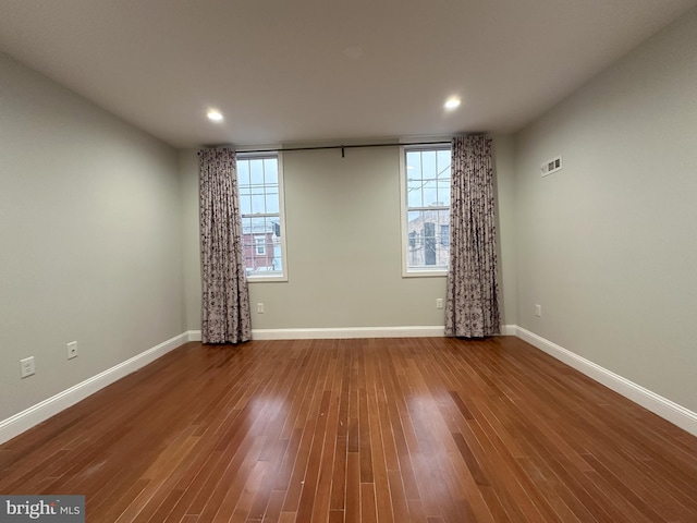 unfurnished room with hardwood / wood-style flooring and plenty of natural light