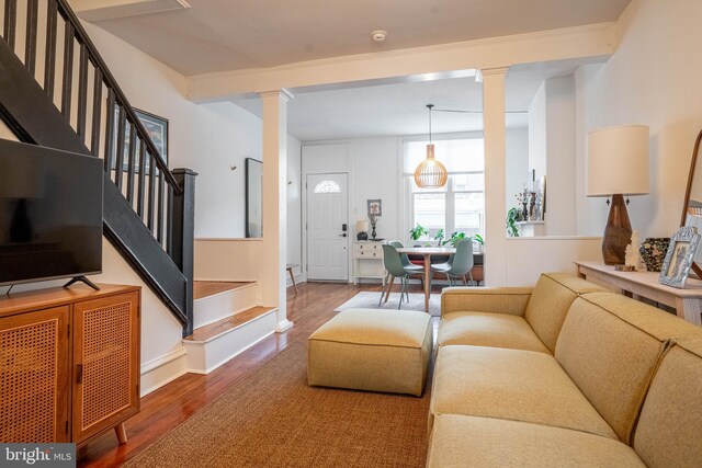 living room with beam ceiling, hardwood / wood-style flooring, and ornate columns