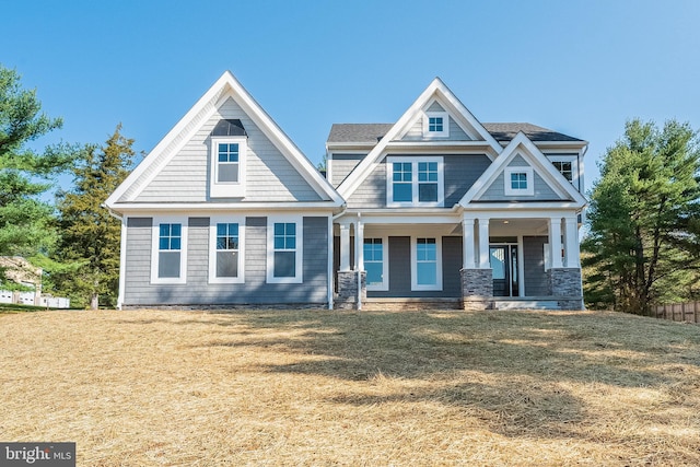 craftsman house with covered porch and a front lawn