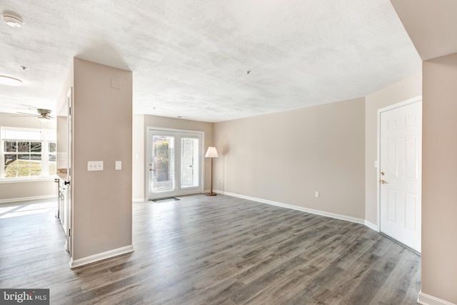 unfurnished room featuring ceiling fan, dark wood-type flooring, and a textured ceiling