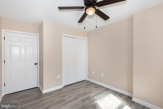 unfurnished bedroom with hardwood / wood-style floors, ceiling fan, and a closet