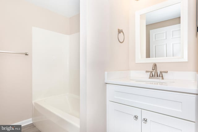 bathroom featuring hardwood / wood-style flooring, shower / bathtub combination, and vanity