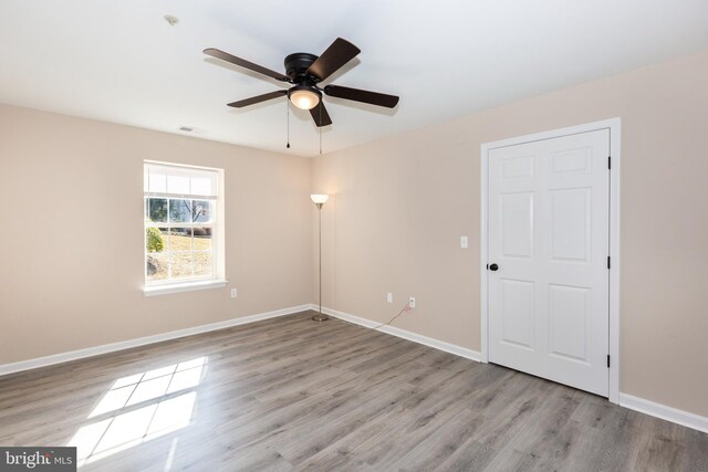 unfurnished room with ceiling fan and light wood-type flooring