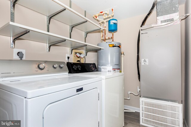 laundry room with washer and dryer, hardwood / wood-style flooring, and electric water heater