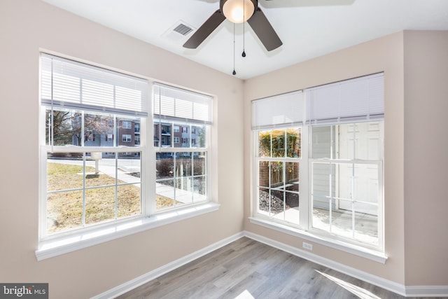 unfurnished sunroom with ceiling fan