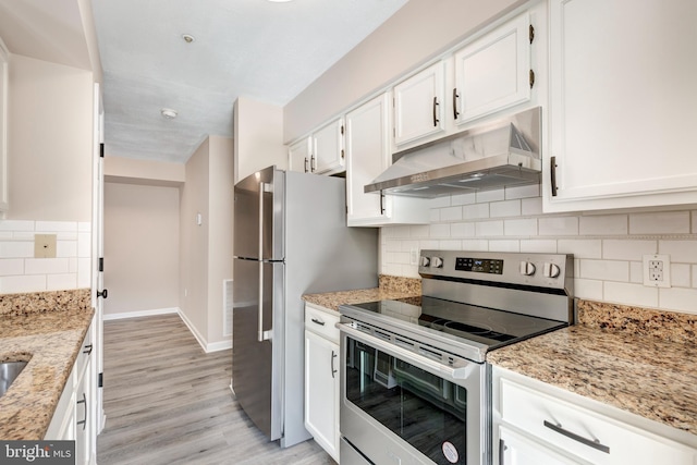 kitchen with light stone countertops, white cabinets, and appliances with stainless steel finishes