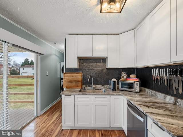 kitchen with sink, dishwasher, white cabinets, and light wood-type flooring