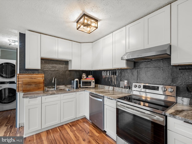 kitchen with sink, appliances with stainless steel finishes, range hood, light hardwood / wood-style floors, and white cabinets