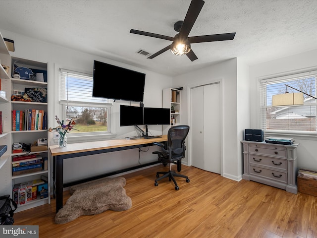 office space featuring a textured ceiling and light wood-type flooring