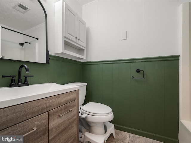 bathroom featuring tile patterned floors, vanity, toilet, and a textured ceiling